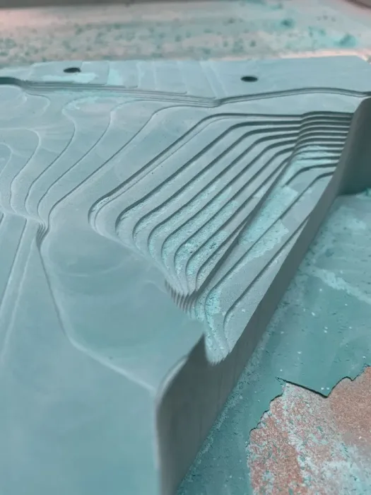 Stepped contour cuts machined into a turquoise epoxy tooling block
