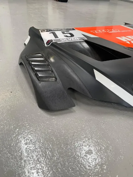 Carbon fibre dive plane and louvred vent on a liveried race bodywork panel